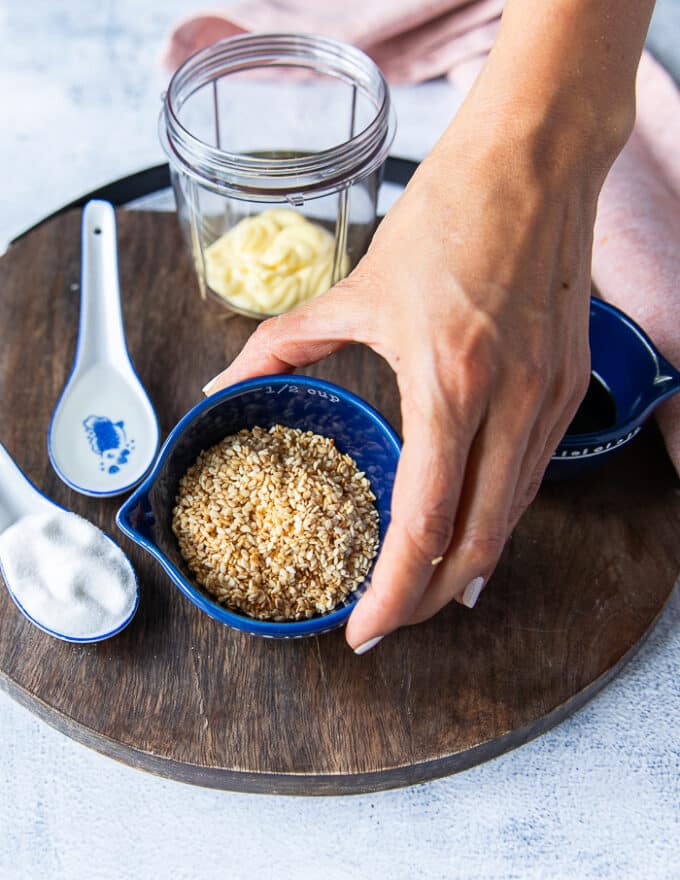 A hand holding the toasted sesame seeds showing how golden and ready to make dressing