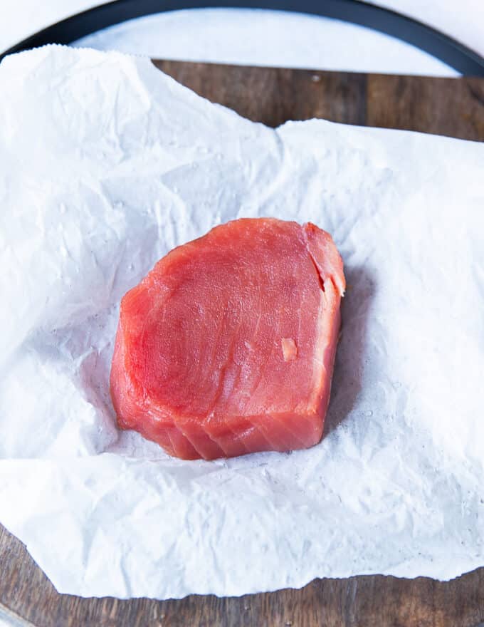 One fresh ahi tuna steak on a parchment paper