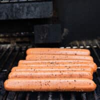 The hot dogs are placed on a medium hot grill