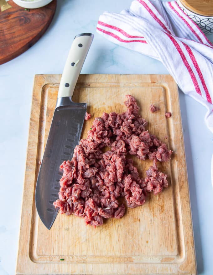 finely chopped, almost like coarse ground looking beef on the cutting board showing the correct texture