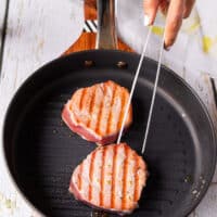Perfect tuna steaks seared on one side, flipped to show the grill marks and continue cooking on the other side